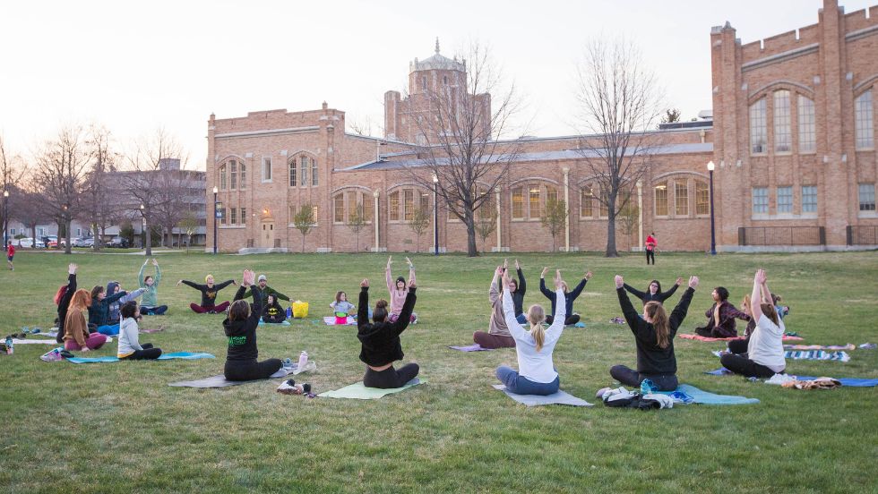 Students practicing yoga at sunrise