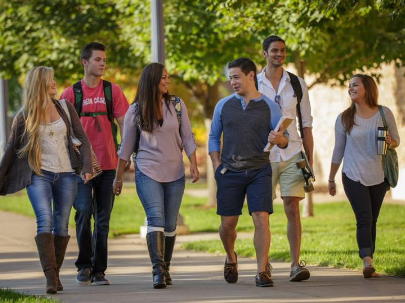 A friendly group of students chat as they walk across campus