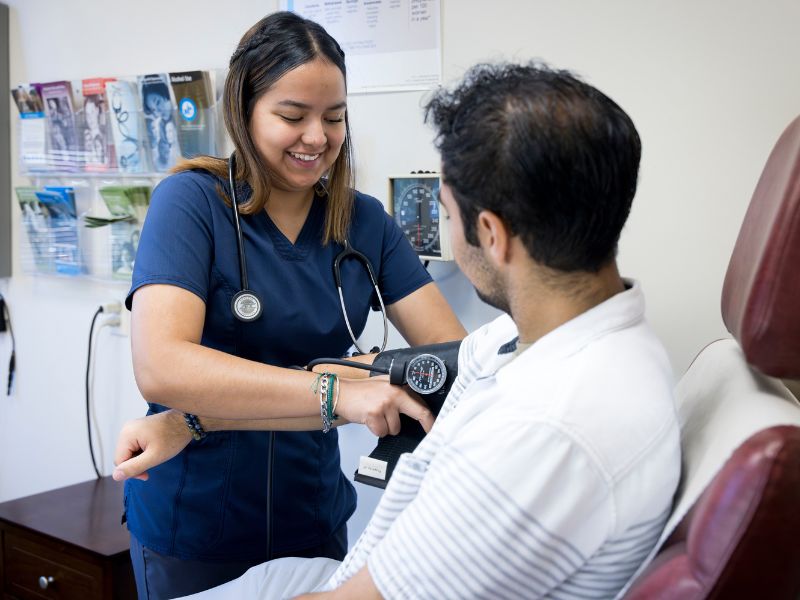 A patient sits has their blood pressure checked.