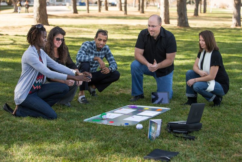 students and instructor sitting around a project