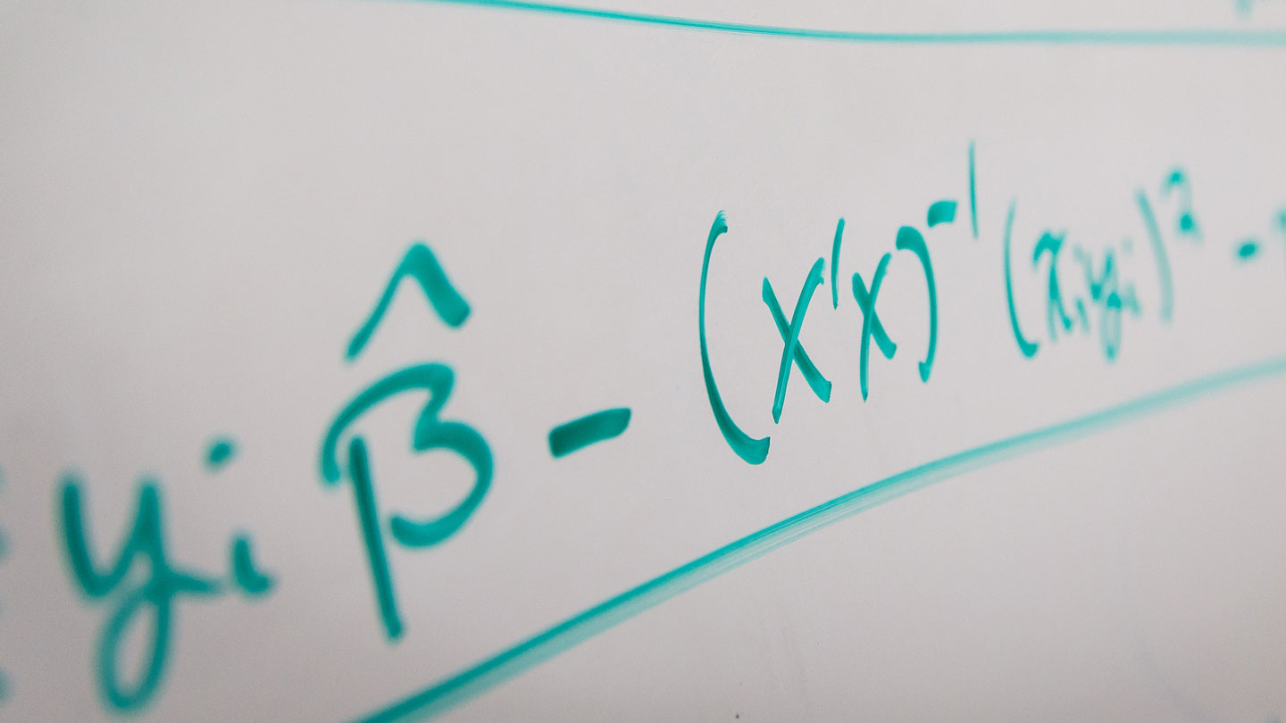 White board showing mathematical formulas.