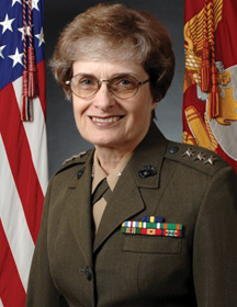 A headshot of Carol Mutter in her uniform and an American flag behind her