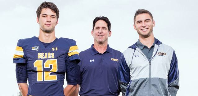 UNC football coach Ed McCaffrey and two football players standing side-by-side.