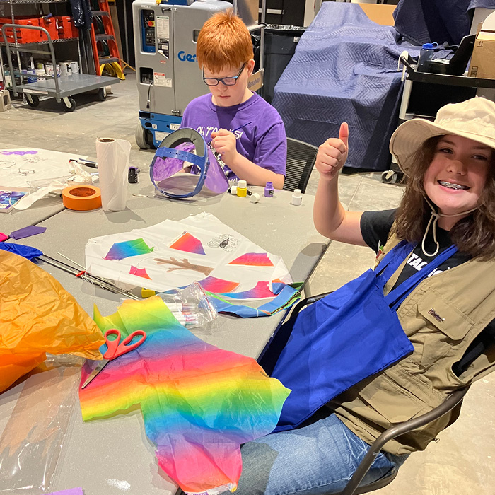 2 students making colorful kites and masks at UNC Exploring Arts Camp.