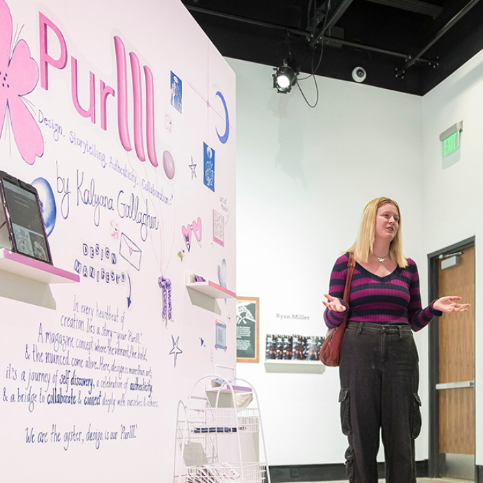 A student presenting work at the Graphic Design Senior Show.