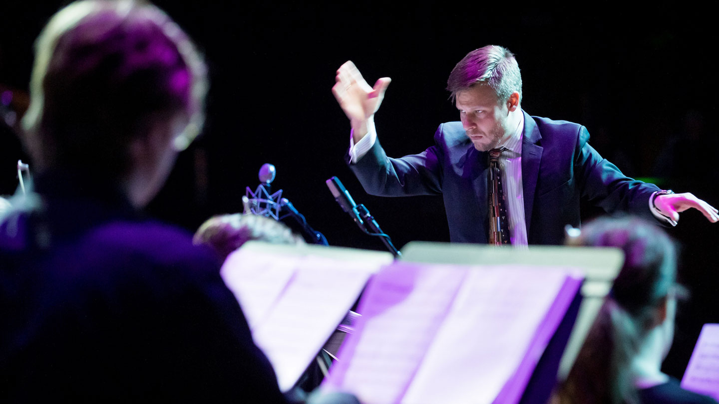 Jazz orchestra conductor conducting.