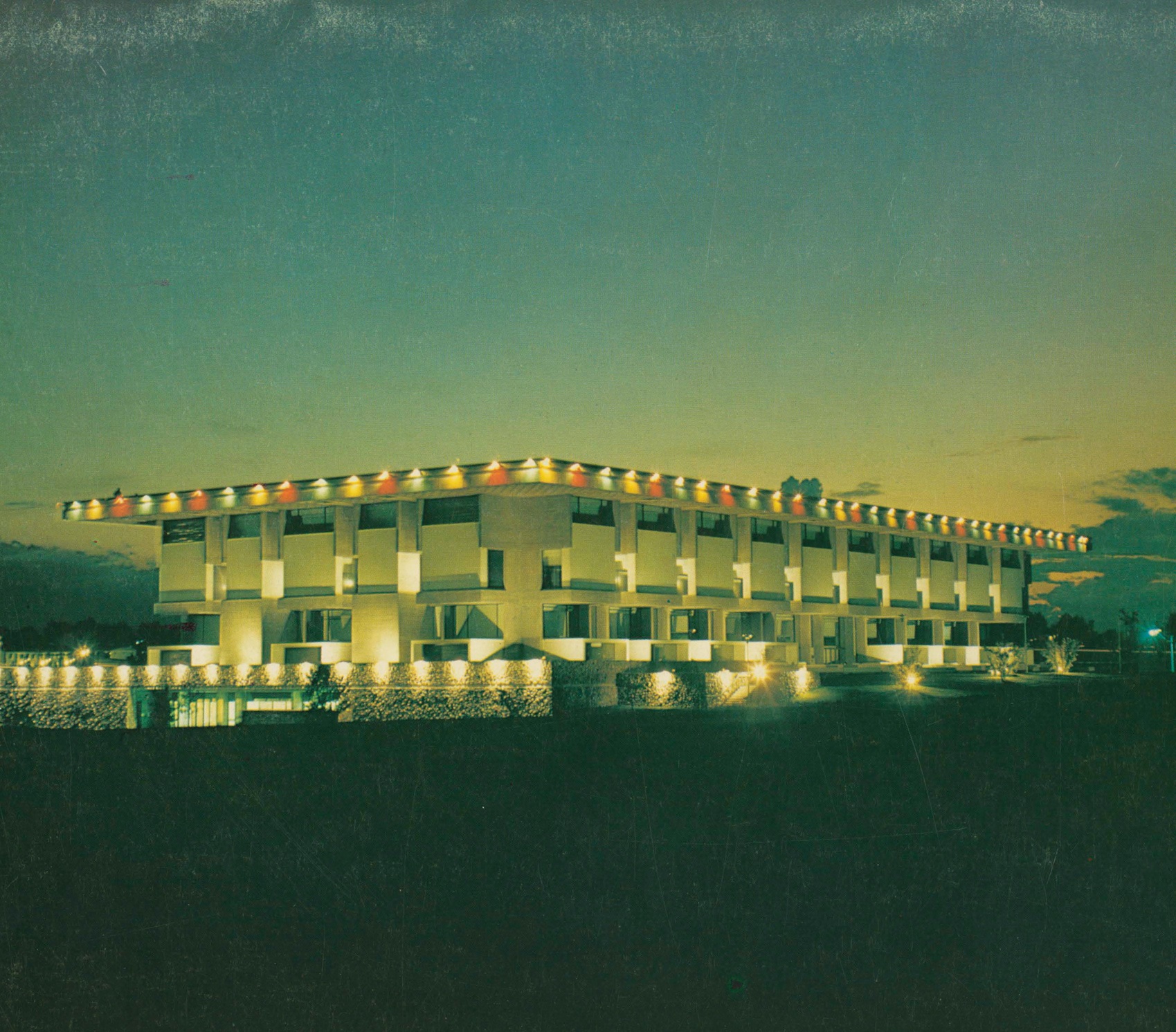 Exterior of Michener Library at dusk with multicolor lights along the edge of the roof