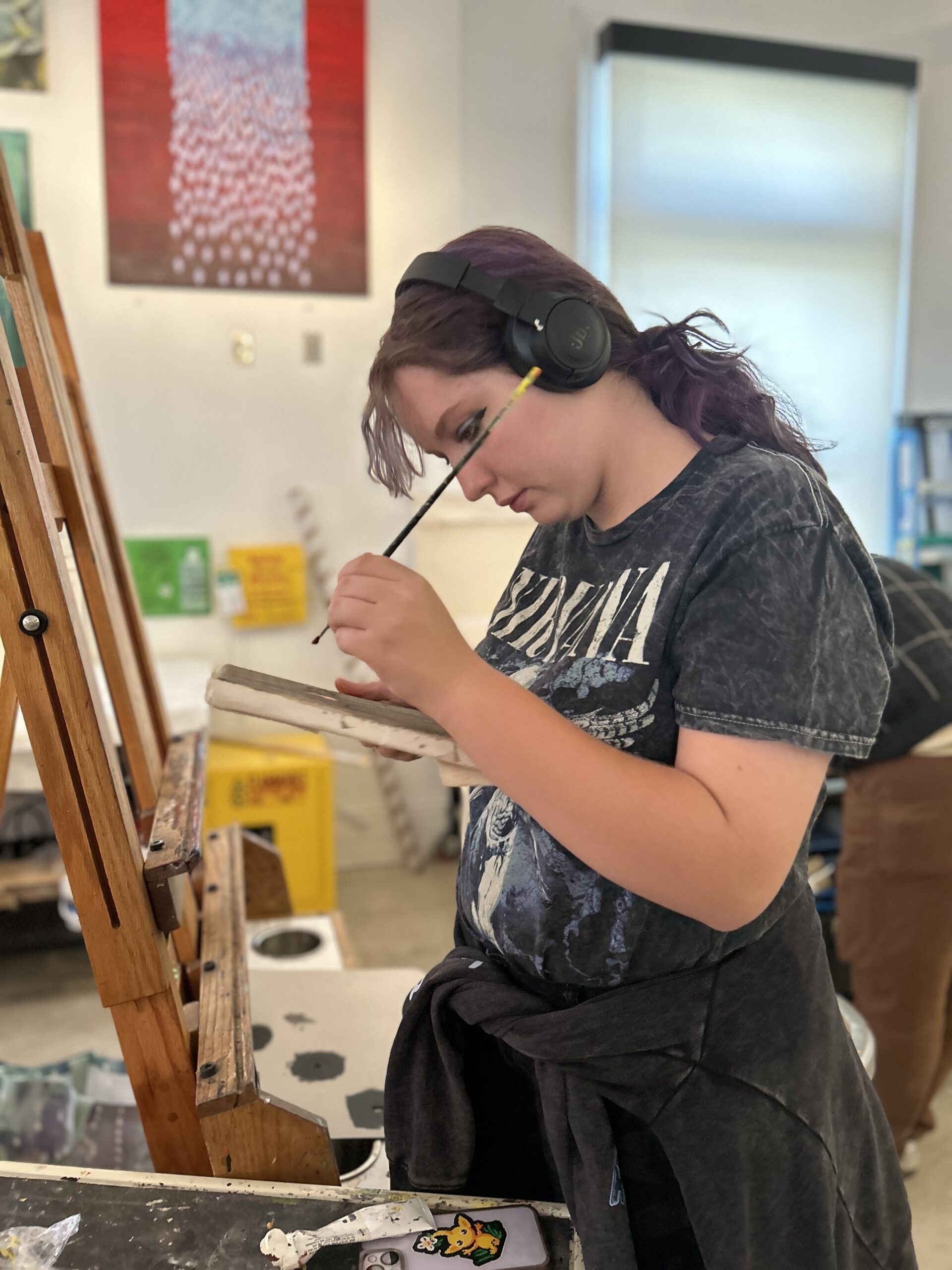 A student putting color on their brush in the painting studio.