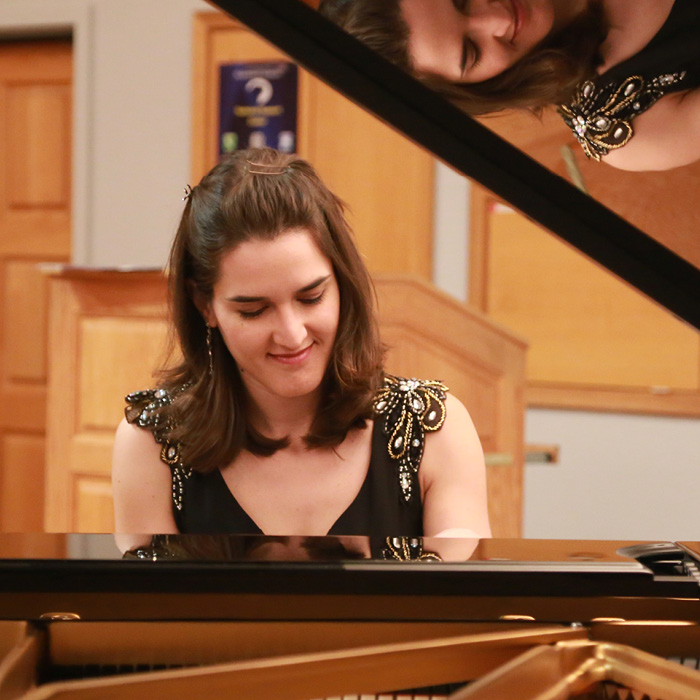 Female pianist playing in a piano recital.