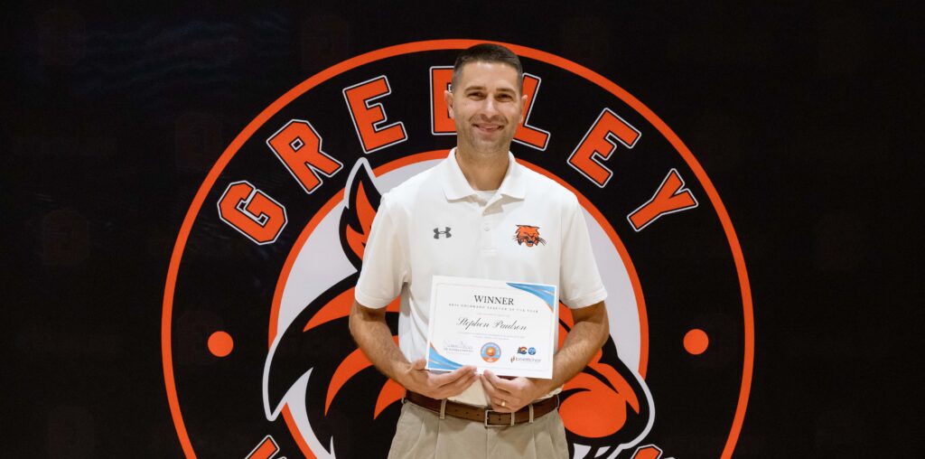 Stephen Paulson smiling with his paper award in hand