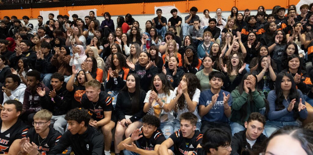 A large crowd of students sitting on bleachers and cheering