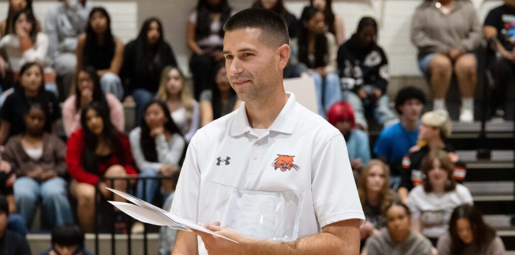 Stephen Paulson holding an award at an assembly
