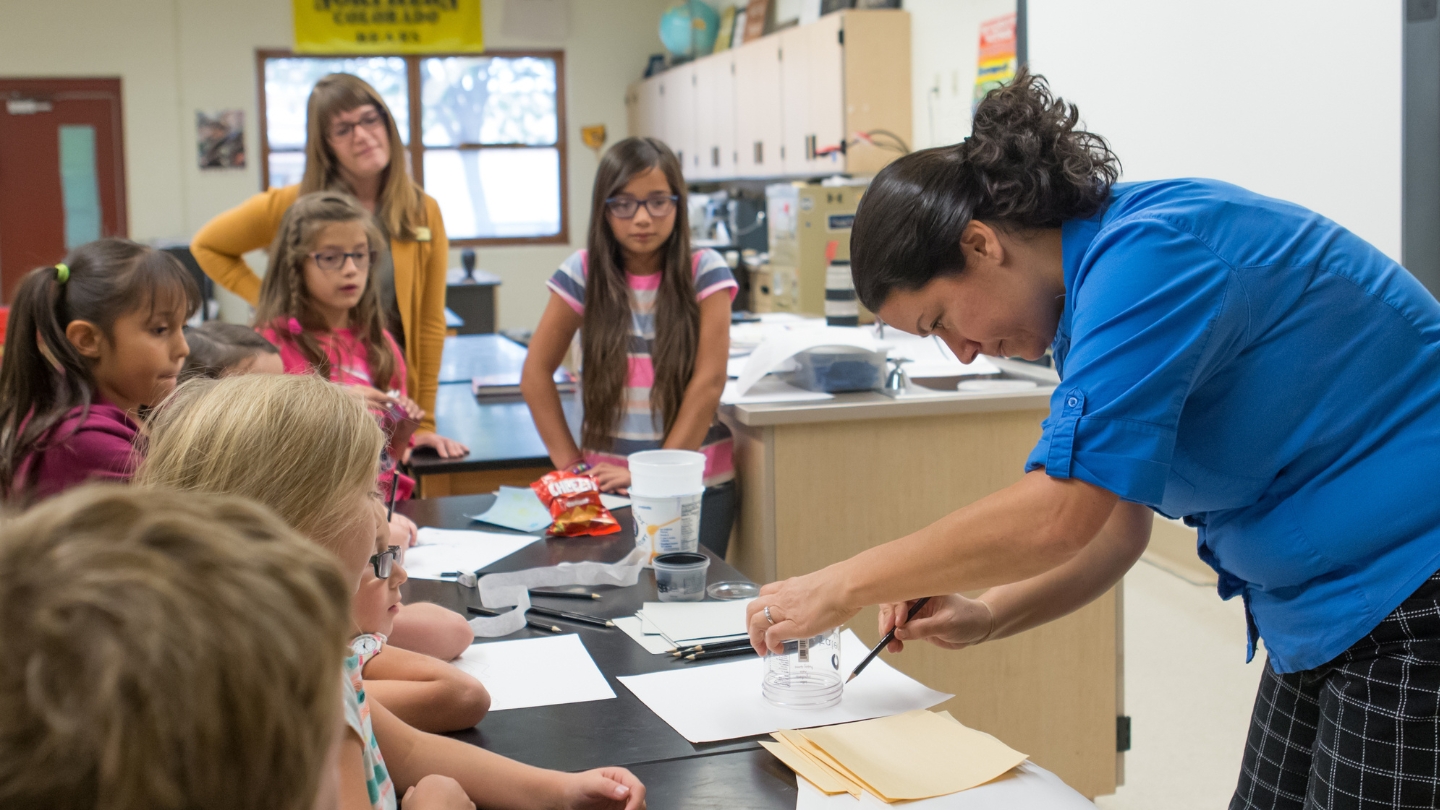 A teacher is demonstrating an assignment to her early childhood education students