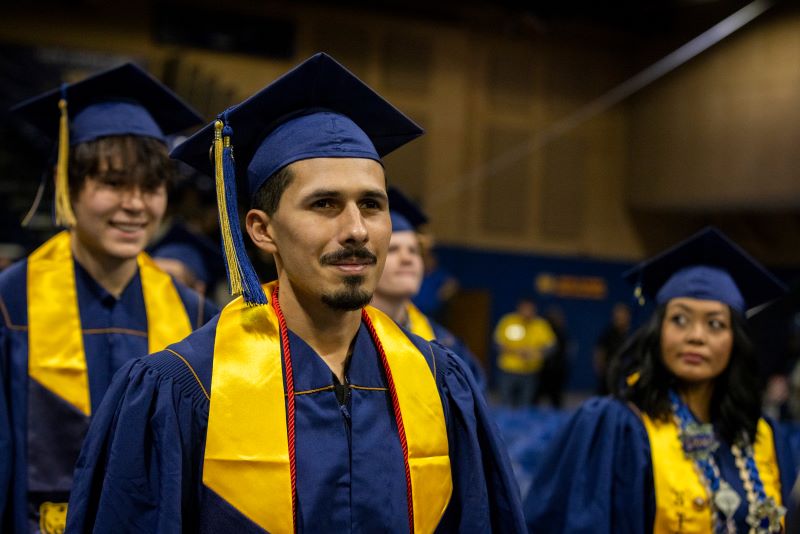 student wearing graduation regalia at commencement