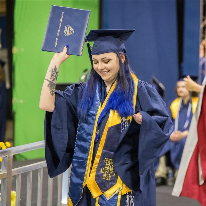 McNair student graduating at commencement, walking across stage