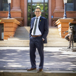Dr. Steven Ellias, dressed in a suit, standing behind Kepnar Hall 