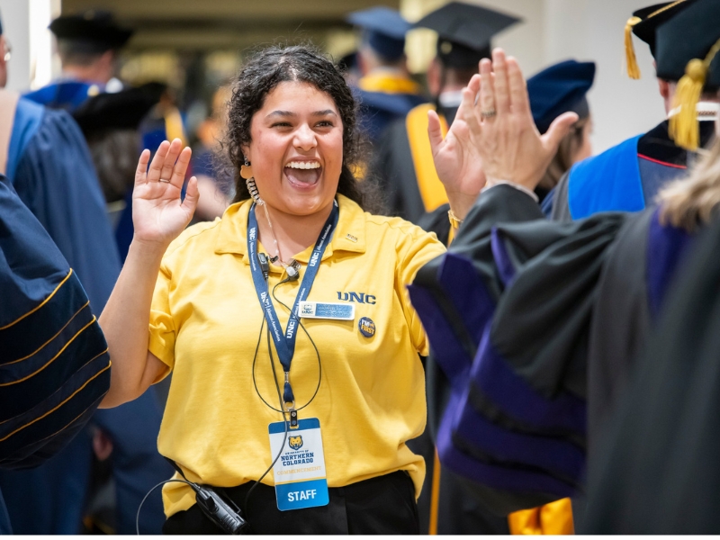 Teresa Castro, '21, high fives a new grad at commencement 2026