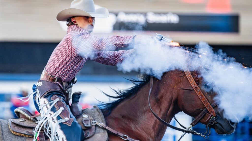 A boy riding a horse and shooting a light gun