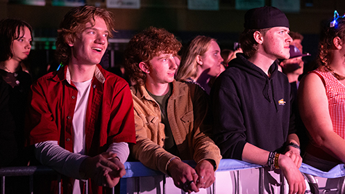 Students leaning over the barrier at the 2025 Spring Concert.