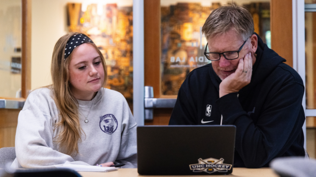 Lexie Martin on the left looking at her computer with a mentor next to her