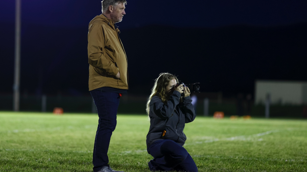 Lexie Martin crouched on her knees holding a camera