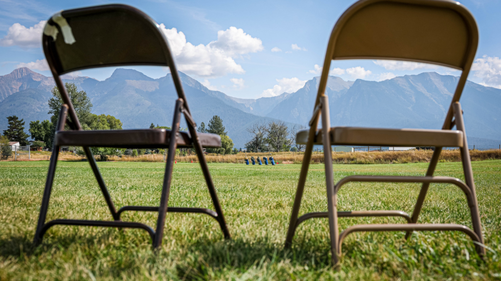 Two metal fold up chairs in front of mountains