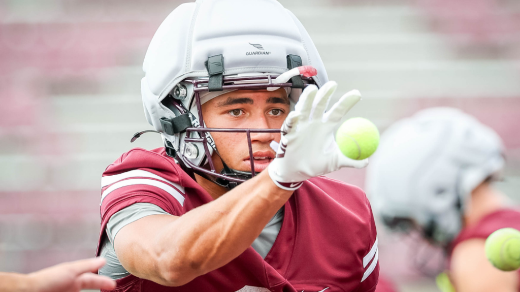 A football player catching a tennis ball