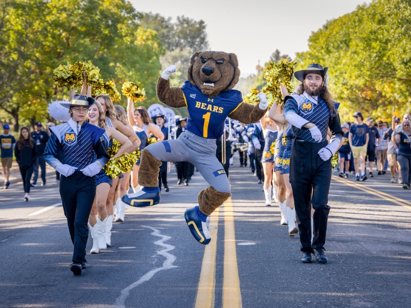 UNC Bear mascot Klawz jumping at the front of the homecoming parade, 2025