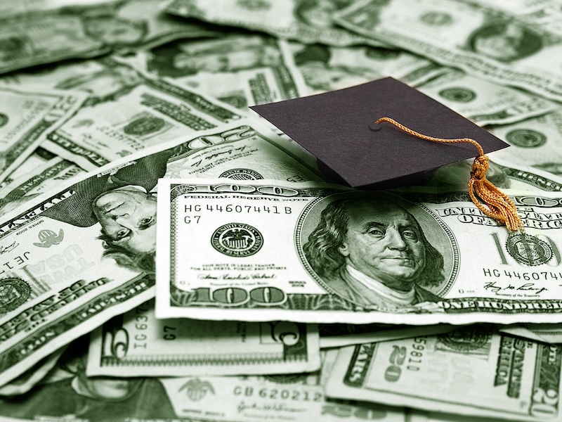 Small graduation cap and money to communicate the concept of educational cost