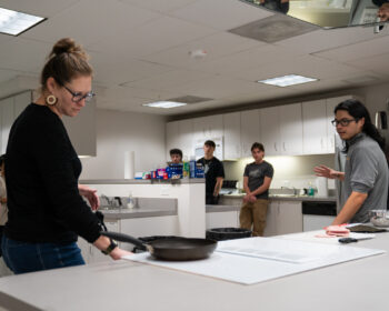 Professor Lisa Caldwell demonstrating food recipes in the Food Lab