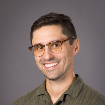 Headshot photo of Dannon Cox in front of a gray background