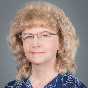 Headshot photo of Diane Erdbruegger in front of a gray background