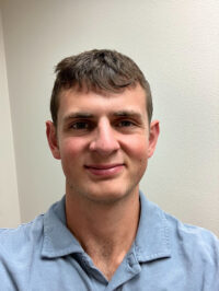 Headshot of Hayden Hyman, peer mentor. Young man wearing a light blue shirt.