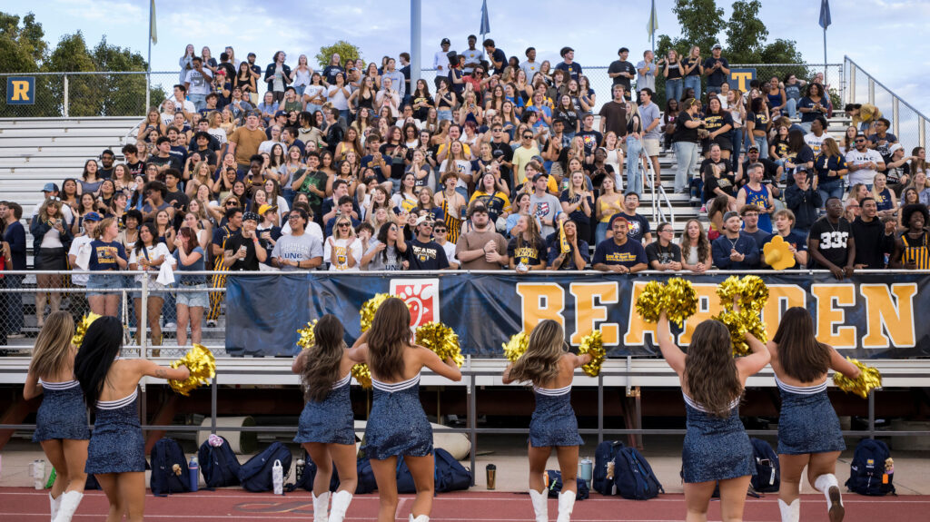 Cheerleaders cheering at fans in the stands