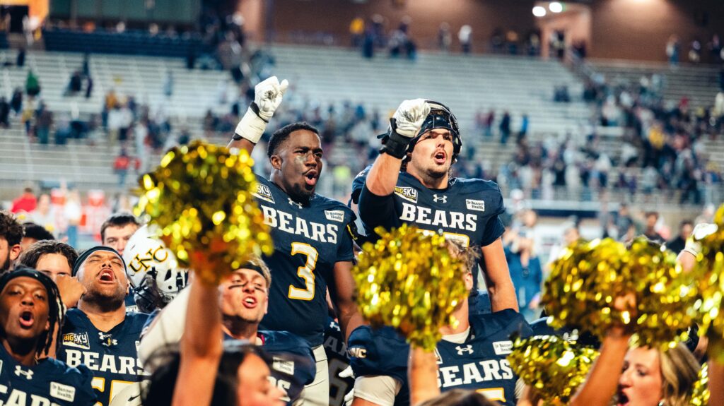 Two UNC football players cheering after the game