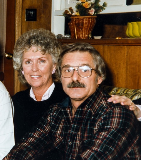 Maxine and Don Schwartz sitting next to each other on a couch smiling