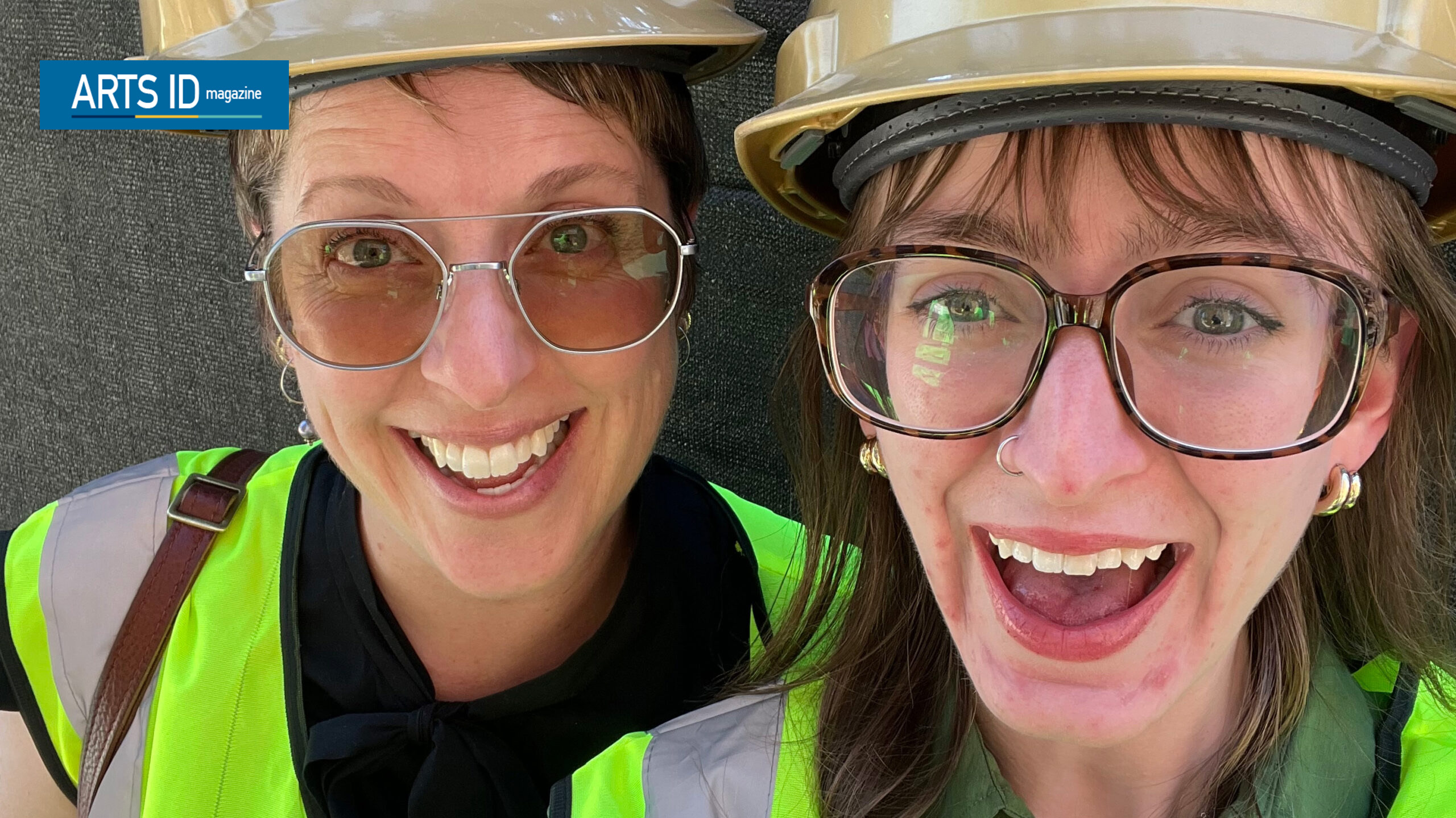Two women in hard hats and glasses smiling