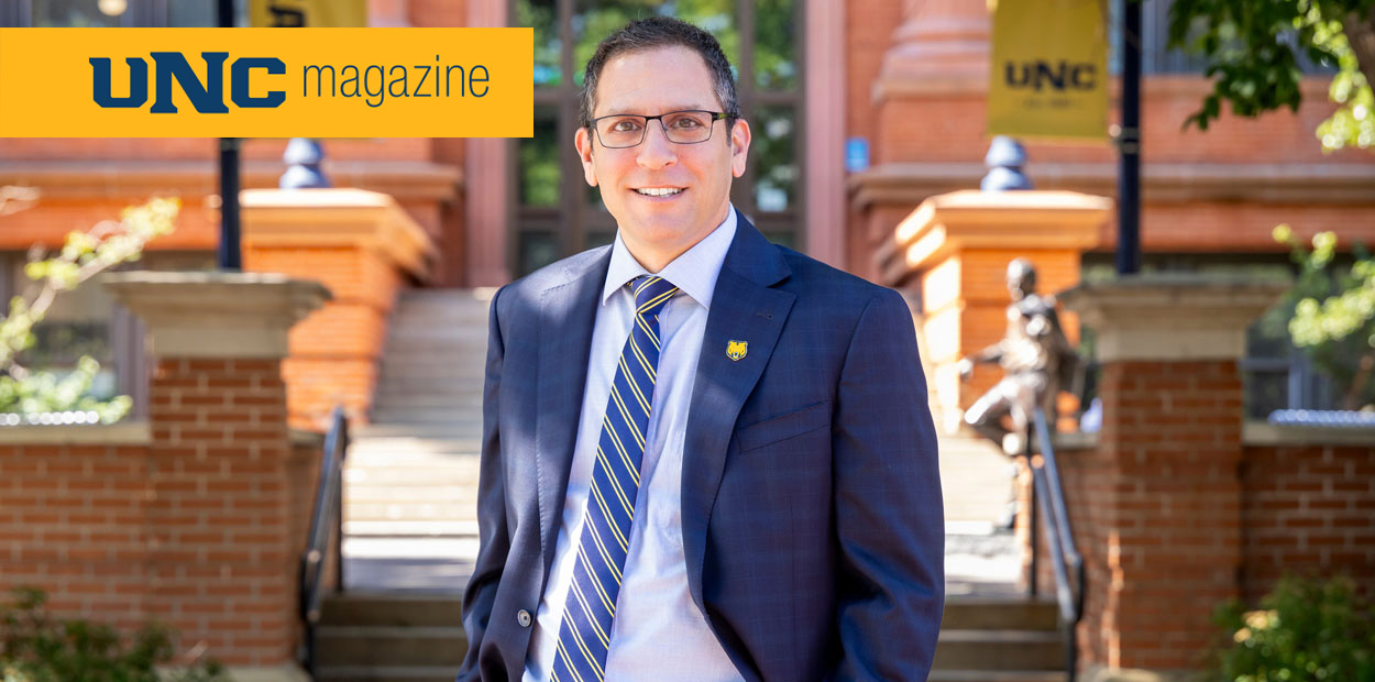 Steve Elias wearing a tie and suit and glasses smiling at the camera