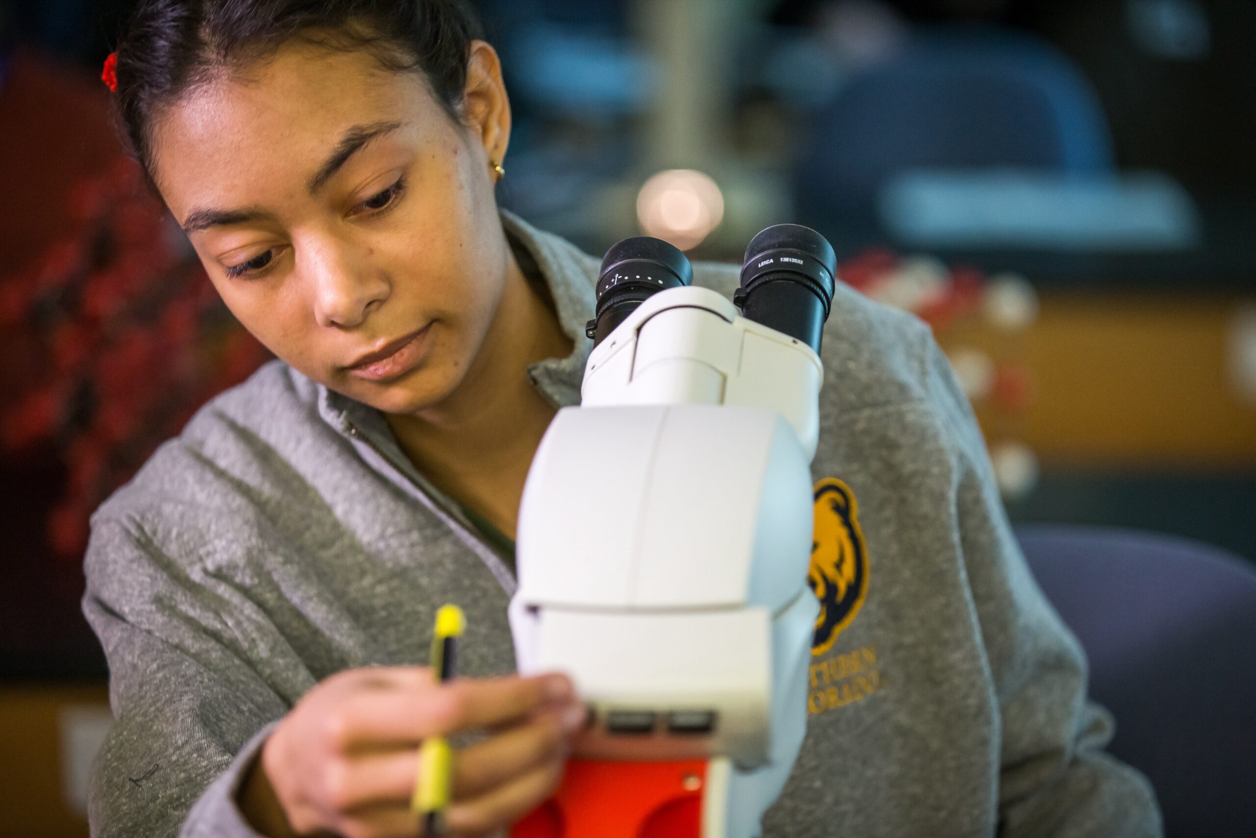 Female student using a microscope.