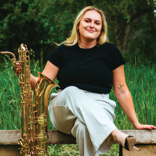 Allison Young sitting and holding a saxophone