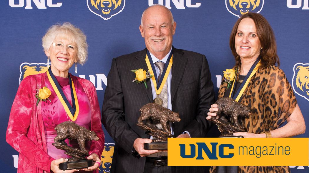 The three UNC Honored Alumni for 2026 posing together and holding their awards.