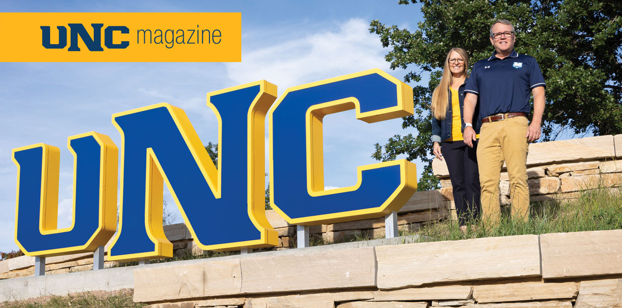 Andy Feinstein and his wife standing next to a UNC sign
