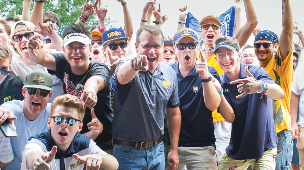 Andy cheering with a group of UNC students during a tailgate.
