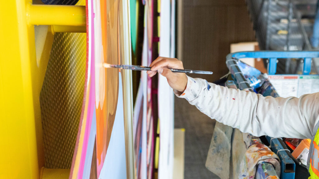Armando Silva's hand painting his mural inside the College of Osteopathic Medicine building