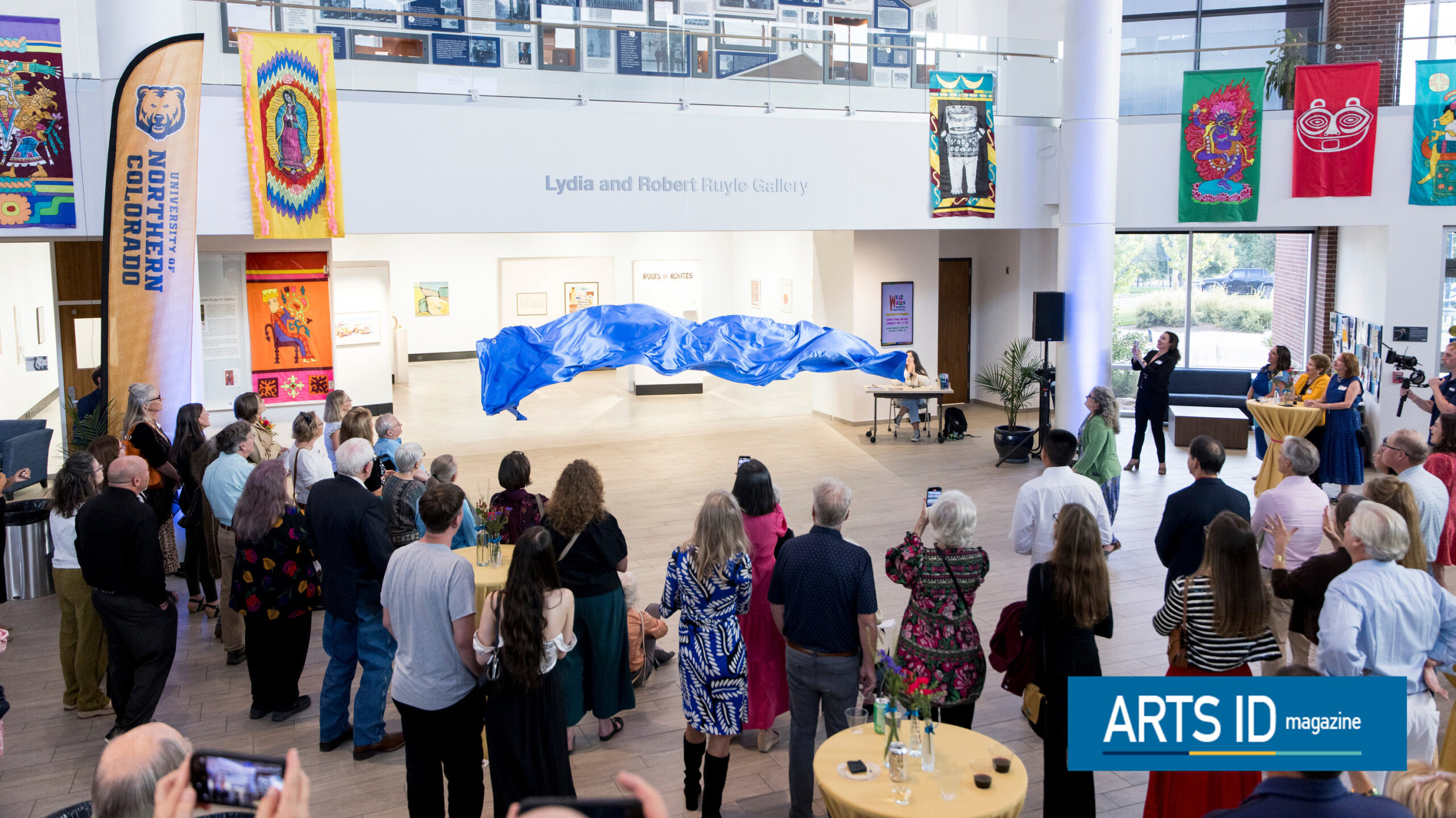 A banner on the Lydia Ruyle Gallery falling down to the ground in front of a crowd
