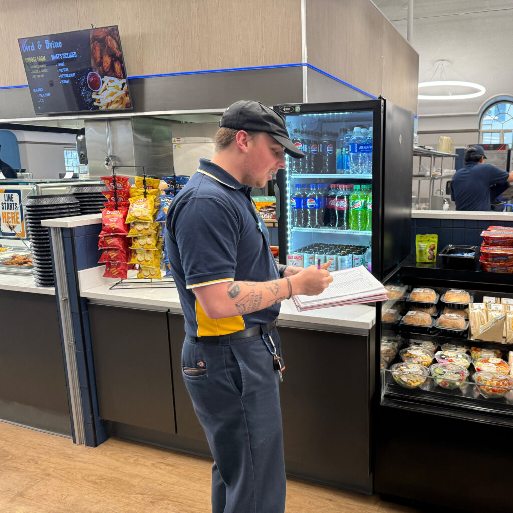 Blake Hays holding a notbeook and a pen while working at Holmes