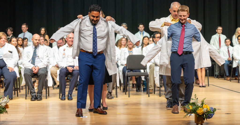 Two med students getting white coated
