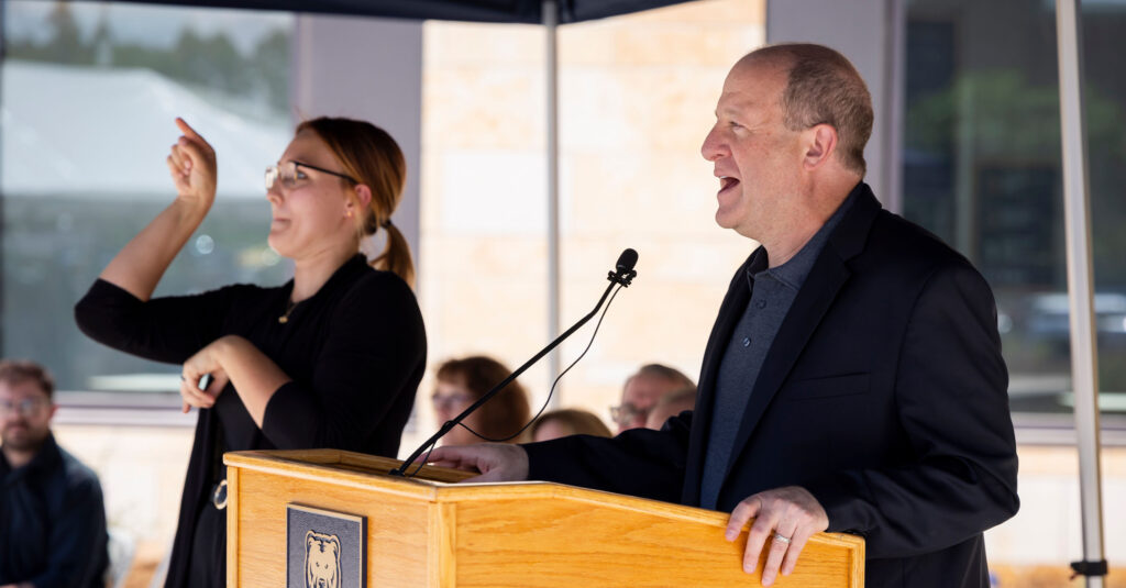 Gov. Polis speaking at the COM ribbon cutting ceremony