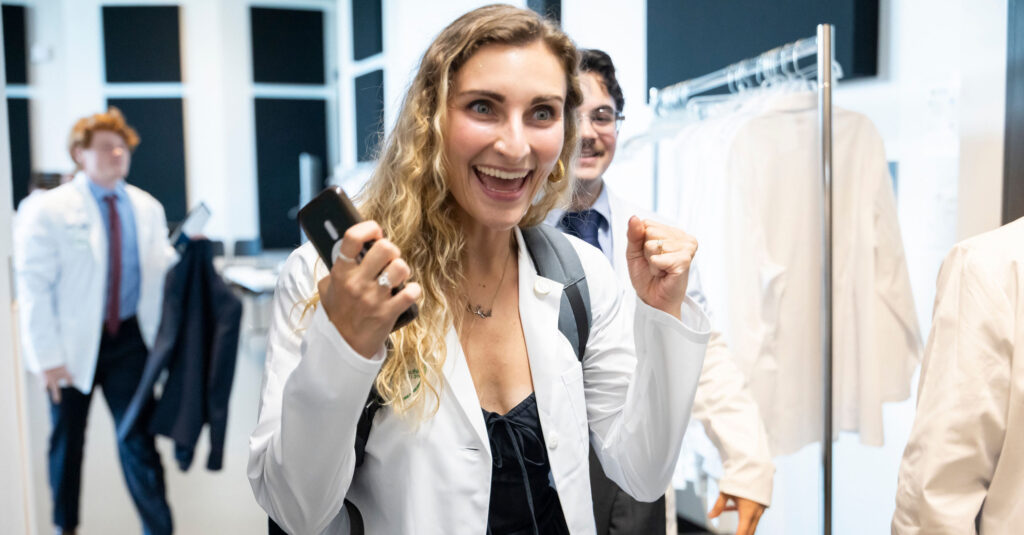 A med student smiling in her white coat