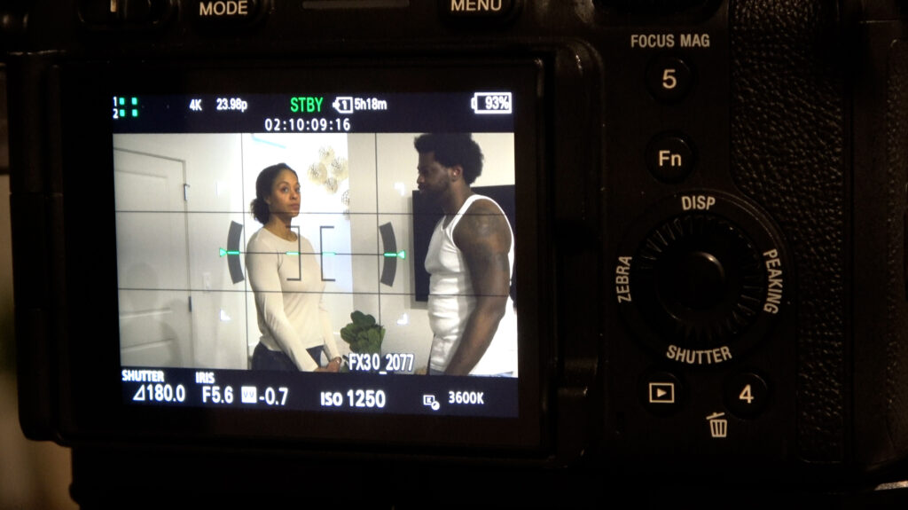 A close up of a camera filming two actors